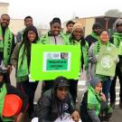 a group of young african-american men and women wearing bright green scarves and holding posters that read "walking with love for healthy babies"