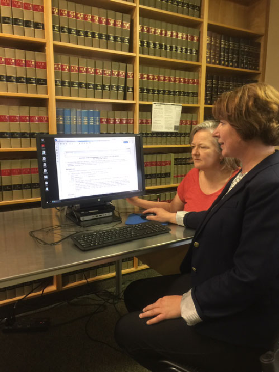 two women in a library working on a computer