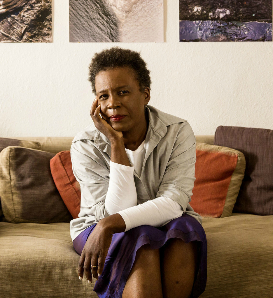 an african american woman sitting on a couch with art 
