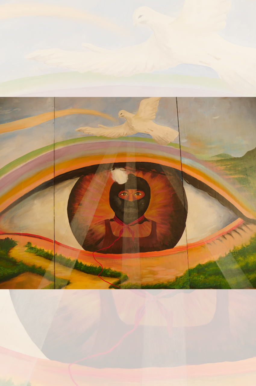 Colorful mural of an eye. In the center of an eye is a person staring directly forward. Above the eye is a white dove soaring in the sky. The eye is so large that it appears to be a part of the landscape in the mural. 