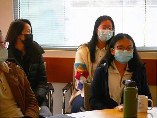 Students sitting at a table wearing masks