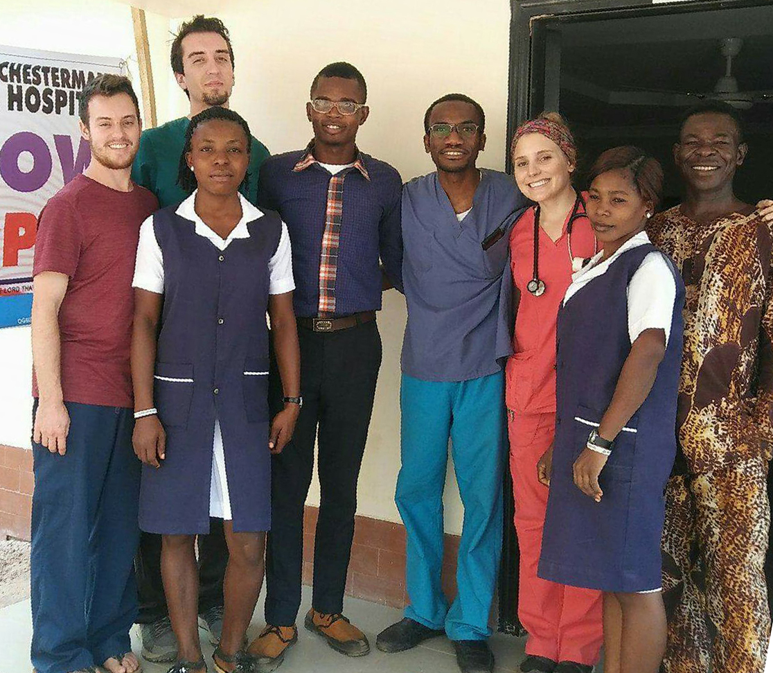 group photo of american and nigerian men and women in front of a new medical clinic 