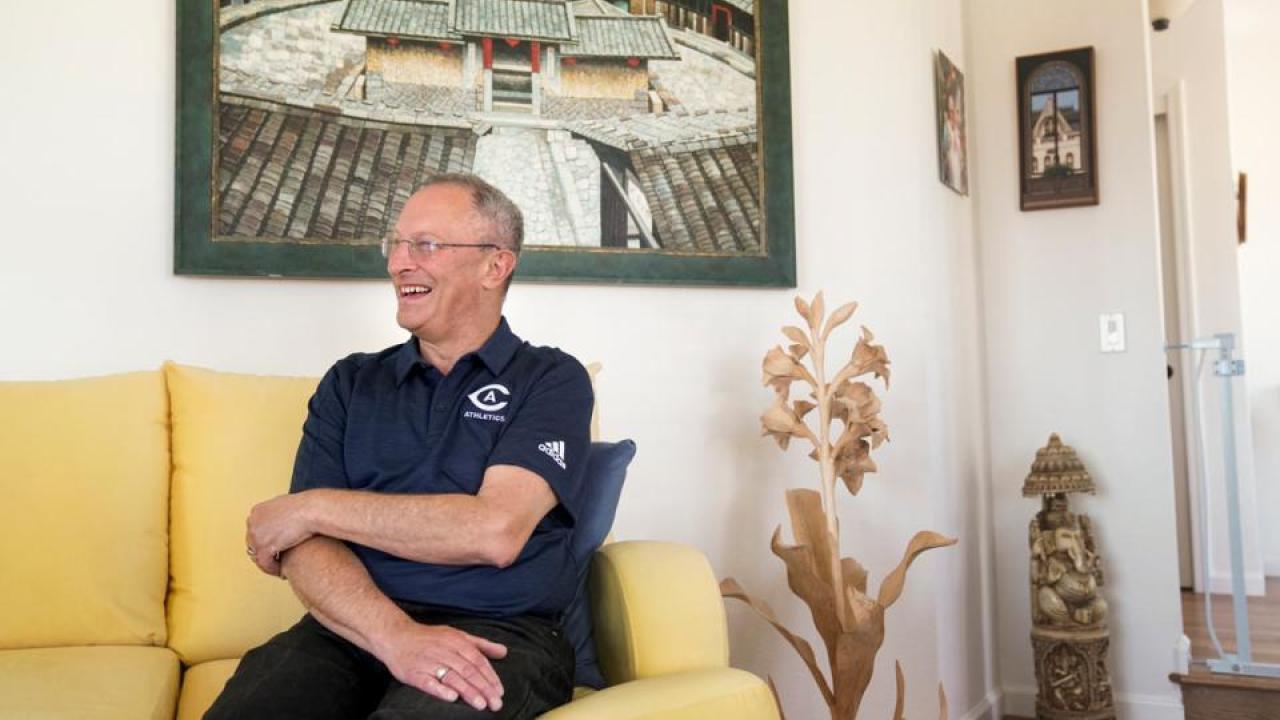 Ralph J. Hexter, at home in mid-May, discussing his tenure in Mrak Hall. (Karin Higgins/UC Davis) man on a yellow couch smiling