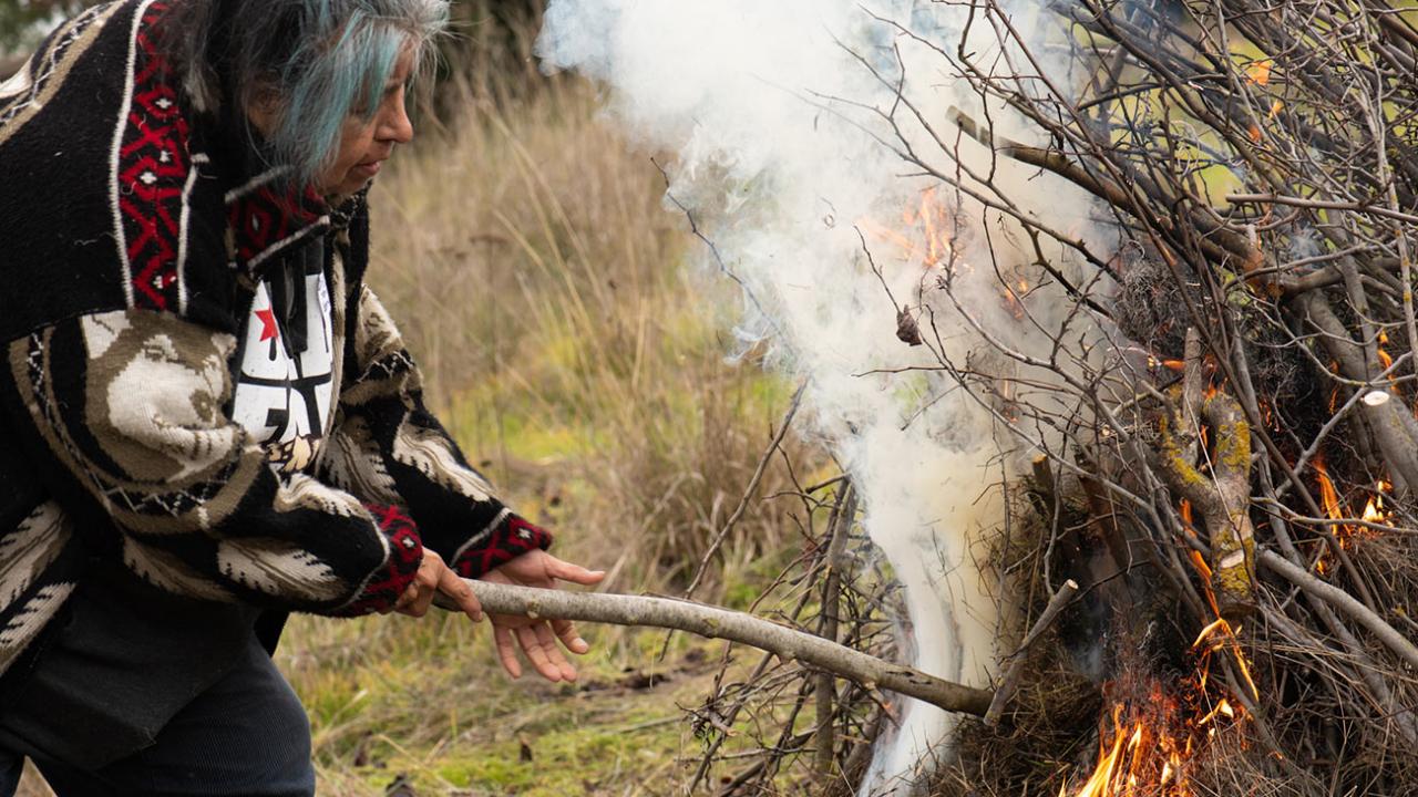 a woman burning a mass of sticks