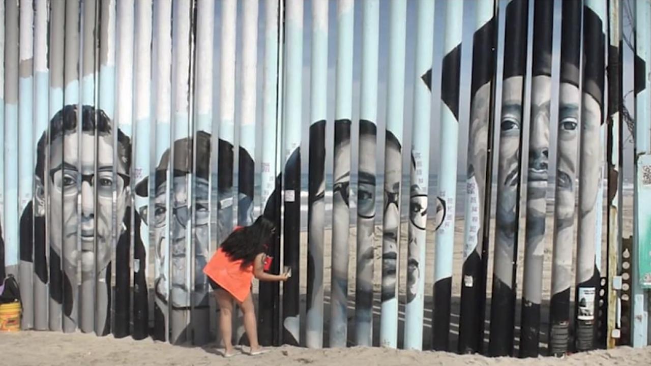 UC Davis graduate student Lizbeth de la Cruz Santana is a Humanizing Deportation team member. Said de la Cruz Santana about the project, "It has allowed me to grow, not just academically, but also personally." (UC Davis video still) a woman bent over paining on a wall