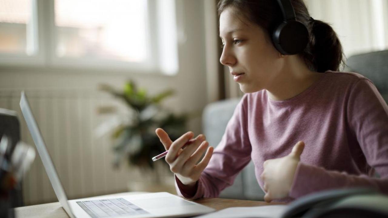 Woman wearing headphones at a computer 