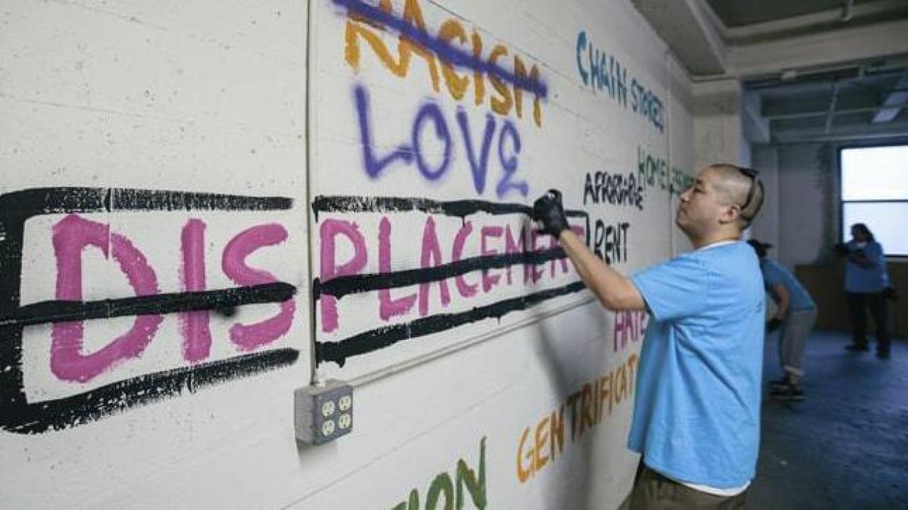 man spray painting on a wall