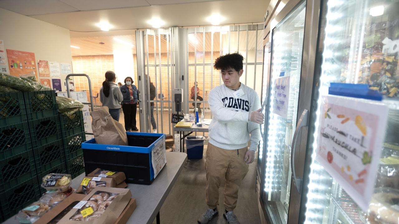 Students stocking shelves and refrigerated cases at the UC Davis Pantry.
