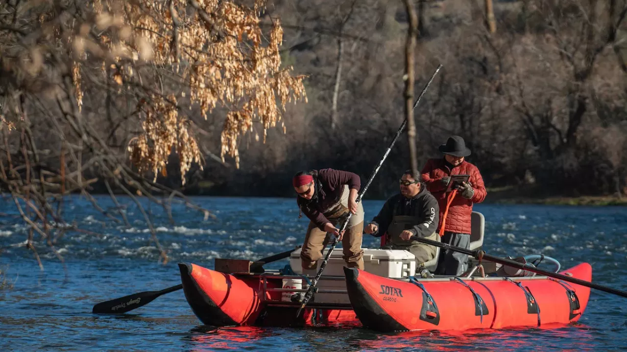Yurok Tribal Fisheries members in red pontoon boat float Klamath River