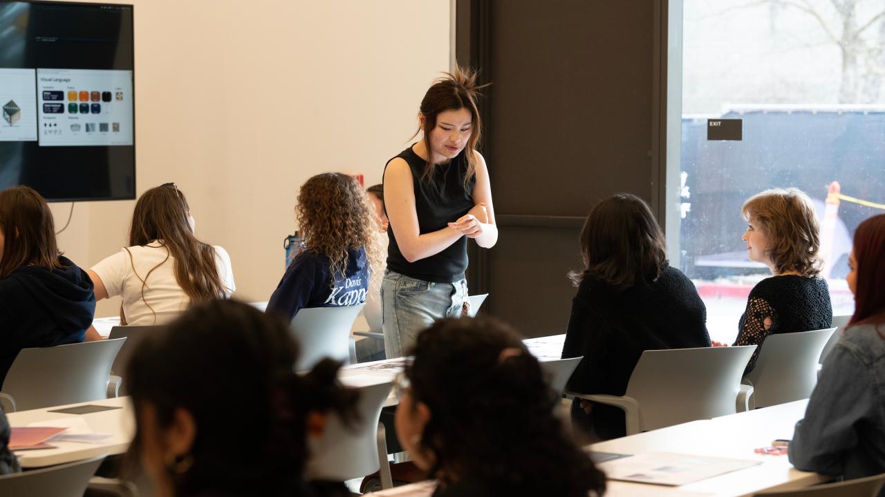 Students seated indoors in a classroom listening to an instructor.