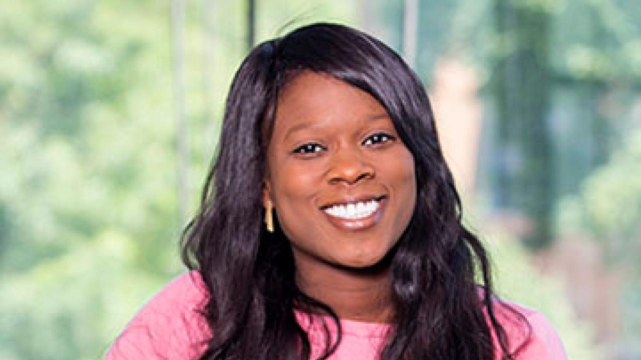Adeola Oni-Orisan smiling (woman with long dark hair, pink blouse)