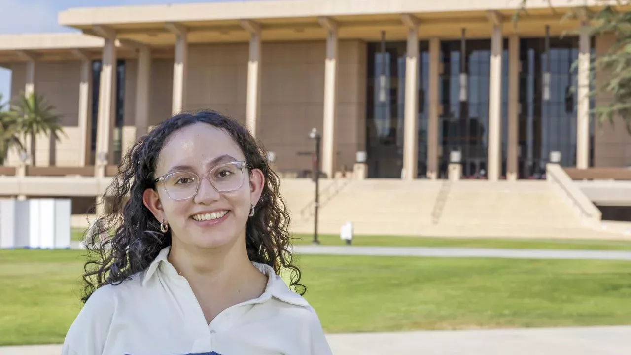 Celine Gomez stands on the lawn in front of the library at CSU, Northridge.