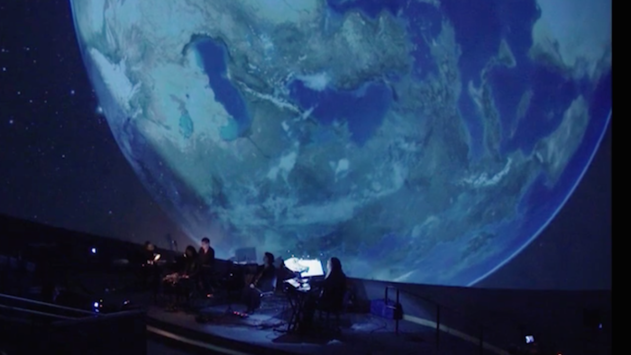 Climate performance in front of a projector displaying Earth