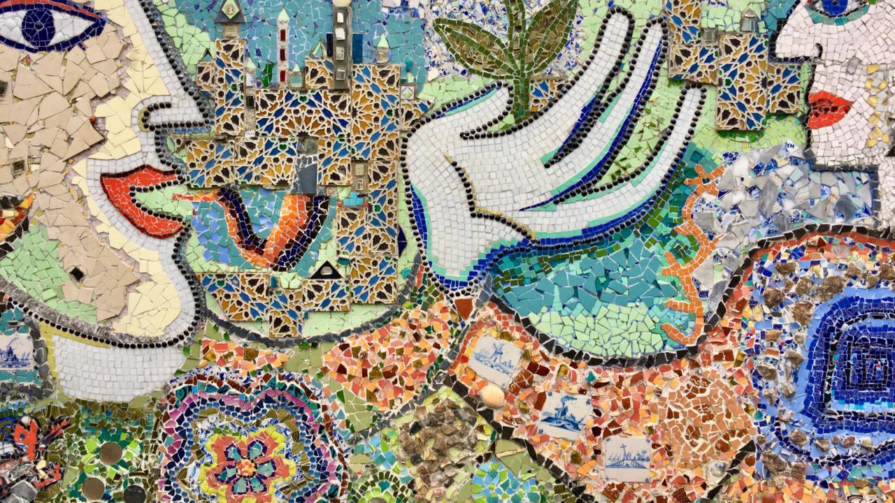 a tile mosaic of a man growing a flower in his hand