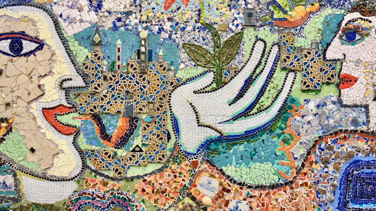 a tile mosaic of a man growing a flower in his hand