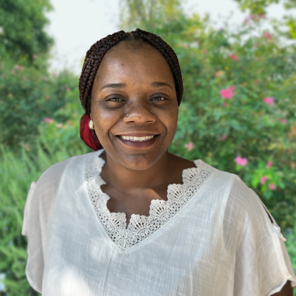 Krystal Oliver, a woman wearing a white blouse smiling directly into the camera for a close-up headshot 