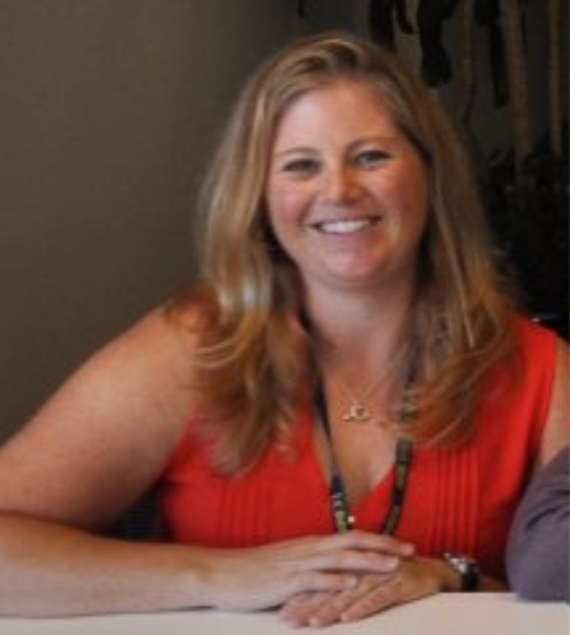 Close up headshot of woman smiling indoors.