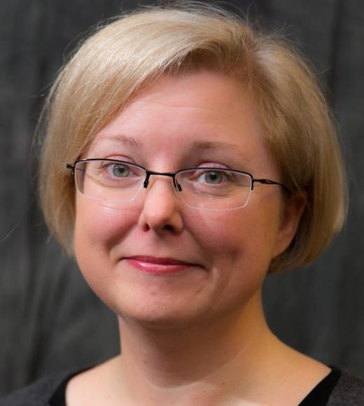 Headshot of a woman with short blonde hair wearing glasses