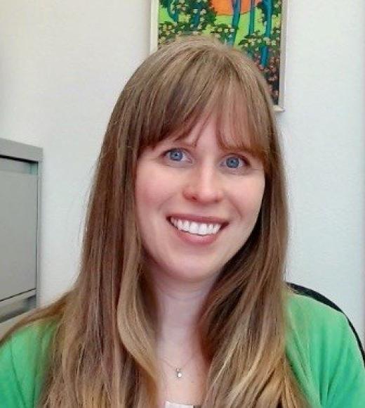 Close up headshot of a woman smiling directly into the camera