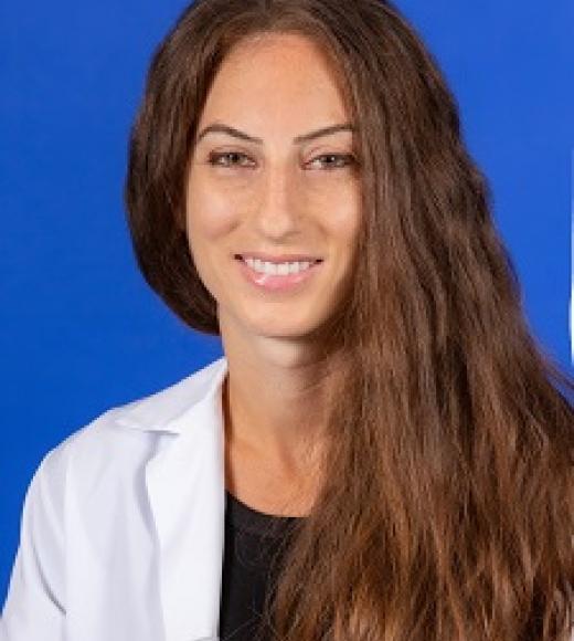 Naomi Hauser smiling in front of a blue background