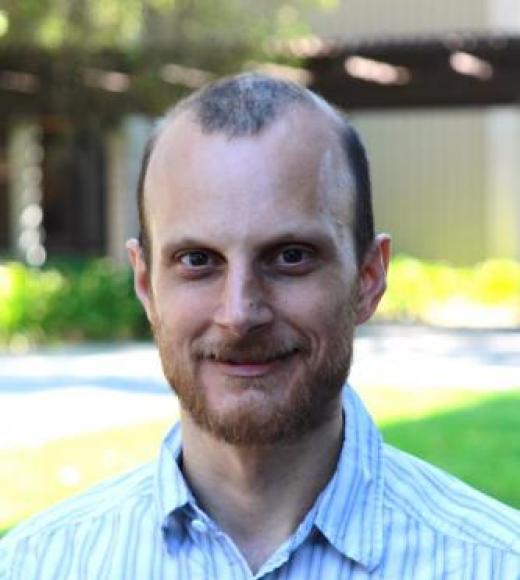 man wearing striped button up shirt smile outside