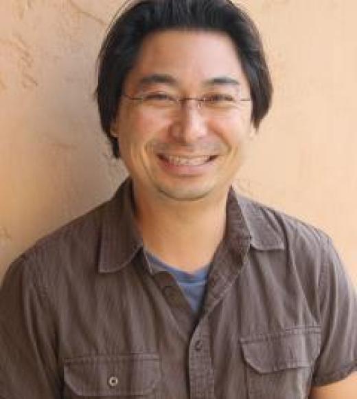 Richard Kim smiling in a brown button up shirt