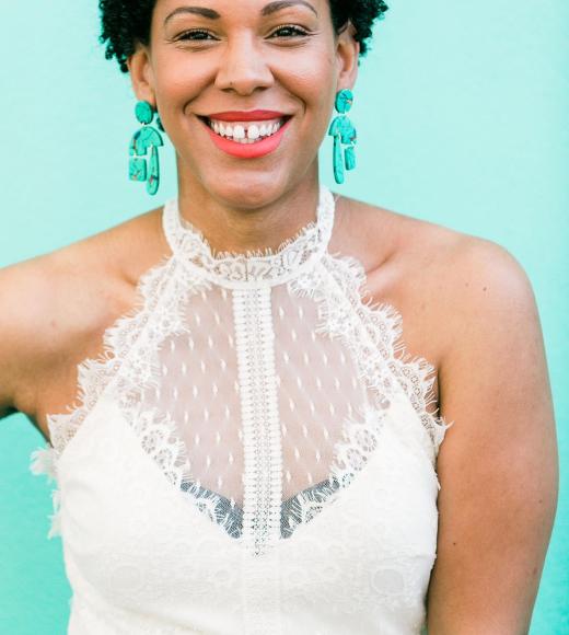 Close up image of a smiling woman in front of a plain blue background