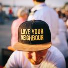man wearing a hat that says "love your neighbor"