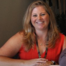 Close up headshot of woman smiling indoors.