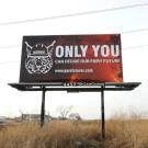 A billboard with Burnie the Bobcat on it that says "ONLY YOU CAN DECIDE OUR FIERY FUTURE" with link to "www.pyrofutures.com"