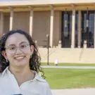 Celine Gomez stands on the lawn in front of the library at CSU, Northridge.
