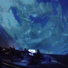 Climate performance in front of a projector displaying Earth