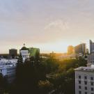 A photograph of Downtown Sacramento and the State Capitol with the sun setting in the background.
