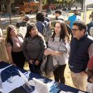 Luis Carvajal-Carmona and three students at a booth at the Graduate and Law School Fair on the Quad. Three female students talk with two male professors at tabling event on UC Davis quad. Another female student is reading a brochure.