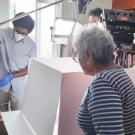 Research team stand around historical documents as they digitize it in a room filled with books