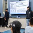 A group of students standing at the front of a classroom.