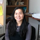 Woman sitting at a desk smiling in her office