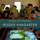 A group of people looking at a table, text overlay reads Science Says Presents: Roger Hangarter