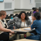 Graduate students sit a table to talk in a group setting