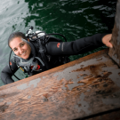 Woman smiling and wearing scuba diving gear in the water