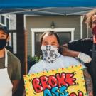 three men with masks and cooking aprons pose for a photo