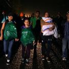Group of Honduran migrants walking together as a group, carrying their backpacks