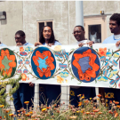 a group of men holding up a mural 