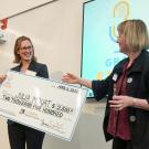 Student stands with giant check made out to Julia Mouat for $2,500