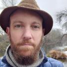 Man outdoors wearing a brown hat