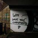 grafitti in a tunnel that reads "let's love our community"