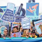 a crowd of people holding posters related to science