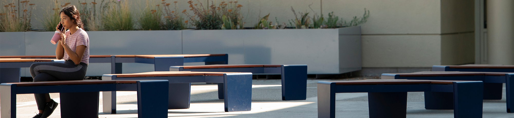 girl on her phone sitting on a bench