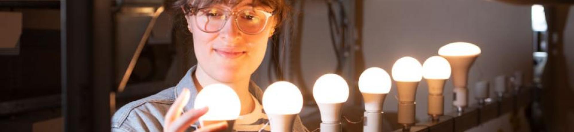 girl looking at a row of lightbulbs