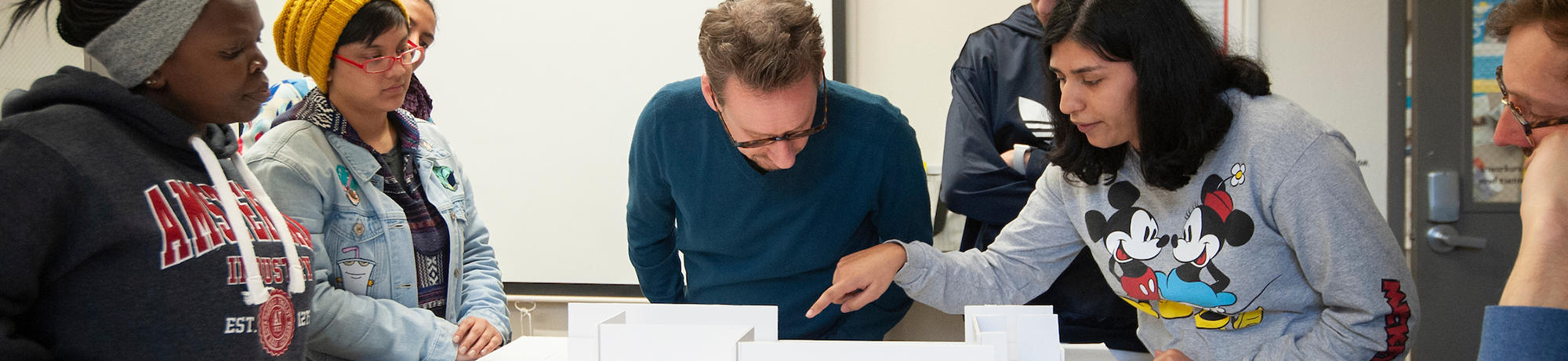 a group of men and women looking at a document on a table